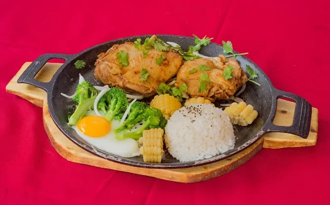 Poulet, riz, œuf et légumes sur plaque chauffante